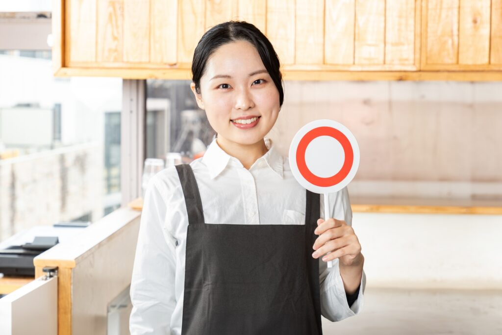 「マル」を掲げる女性